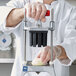 A person in a white coat and gloves using a Vollrath Redco InstaCut 3.5 to cut an apple.