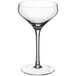 A clear coupe glass with a long stem on a white background.