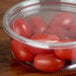A clear plastic Fabri-Kal deli container lid filled with cherry tomatoes.