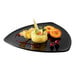 A GET Black Elegance Triangle Plate with food and fruit on it.