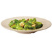 A bamboo melamine bowl filled with salad and croutons.