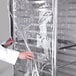 A person in a white lab coat opening a Curtron clear plastic bun pan rack cover.