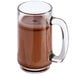 A glass mug with brown Dutch cocoa powder in it on a white background.
