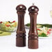 Two Chef Specialties Imperial Walnut pepper mills on a table.