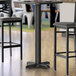 A Lancaster Table & Seating black bar height table with a black base.