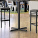 A black Lancaster Table & Seating bar height table base.