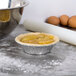 A Durable Packaging pie in a tin with a rolling pin and eggs.