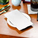 A white Choice dinner napkin with a fork and knife on a table.