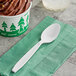 A cup of chocolate ice cream with a Solo white plastic teaspoon on a green napkin.