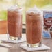 Two glasses of Big Train Low Carb Mocha Blended Ice Coffee with whipped cream.