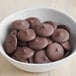 A bowl of chocolate covered cookies with Alpine Dark Chocolate coating.