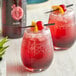 Two glasses of DaVinci Gourmet Classic Grenadine drinks with cherries and straws.