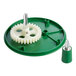A green and white plastic gear on a green disc with a green cap.