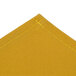 An unfolded gold fabric with a stitched edge.