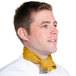 A man wearing a gold chef neckerchief around his neck.