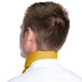 The back of a man wearing a gold chef neckerchief.