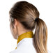 A woman with a ponytail wearing a gold chef neckerchief.