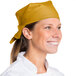 A woman wearing a gold Intedge chef bandana smiling.