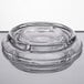 A clear glass Libbey ashtray with a spiral pattern on a table.