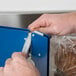 A person using a Shurtape Poly Bag Sealer Tape Dispenser to seal a plastic bag of bread.