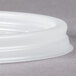 A translucent Cambro lid with a straw slot on a gray surface.