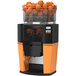 A Zummo Z14 Nature Orange commercial juicer with oranges in the juicing basket.