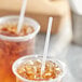 Two plastic cups of iced tea with Choice jumbo clear wrapped straws.