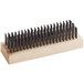 A Texas Brush carbon steel wire grill brush with a wooden handle and black bristles.