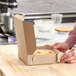 A person opening a Kraft bakery box on a table.