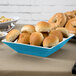 A table with a Seabreeze square melamine bowl filled with bread.