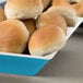 A GET Seabreeze melamine bowl filled with rolls of bread.
