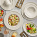 A table with Acopa Condesa warm gray scalloped fruit dishes filled with fruit salad.