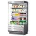 A Turbo Air stainless steel vertical refrigerated display case with drinks and beverages.