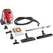 A red Atrix canister vacuum with accessories including a tube and attachments.