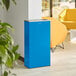 A blue rectangular Lancaster Table & Seating waste receptacle in a room.