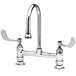 A T&S chrome deck mounted surgical sink faucet with two gooseneck spouts and wrist action handles.