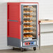 A red and grey Metro C5 heated holding and proofing cabinet with bread on trays.