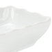 A CAC Super White porcelain bowl with a scalloped edge.
