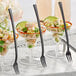 A table with glasses of food, each with a Visions black plastic tasting fork in it.