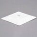 A bright white porcelain coupe dinner plate with a square shape.