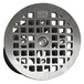 A Guardian Drain Lock Smith floor drain grate with a circular metal top plate with a square grid.