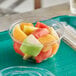 A World Centric compostable clear PLA deli bowl filled with sliced fruit.