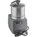 A Robot Coupe stainless steel food processor with a metal lid.