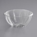 A clear World Centric compostable deli bowl on a gray surface.