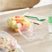 A World Centric clear compostable plastic hinged clamshell container of fruit on a table.