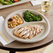 A World Centric compostable fiber plate with grilled chicken, broccoli, and rice on it.