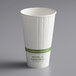 A white World Centric paper hot cup with a green label.