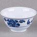 A white Thunder Group melamine rice bowl with blue flowers on it.