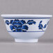 A white melamine bowl with blue flowers and green leaves on it.