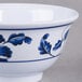 A close up of a white melamine bowl with blue and white lotus flowers on it.